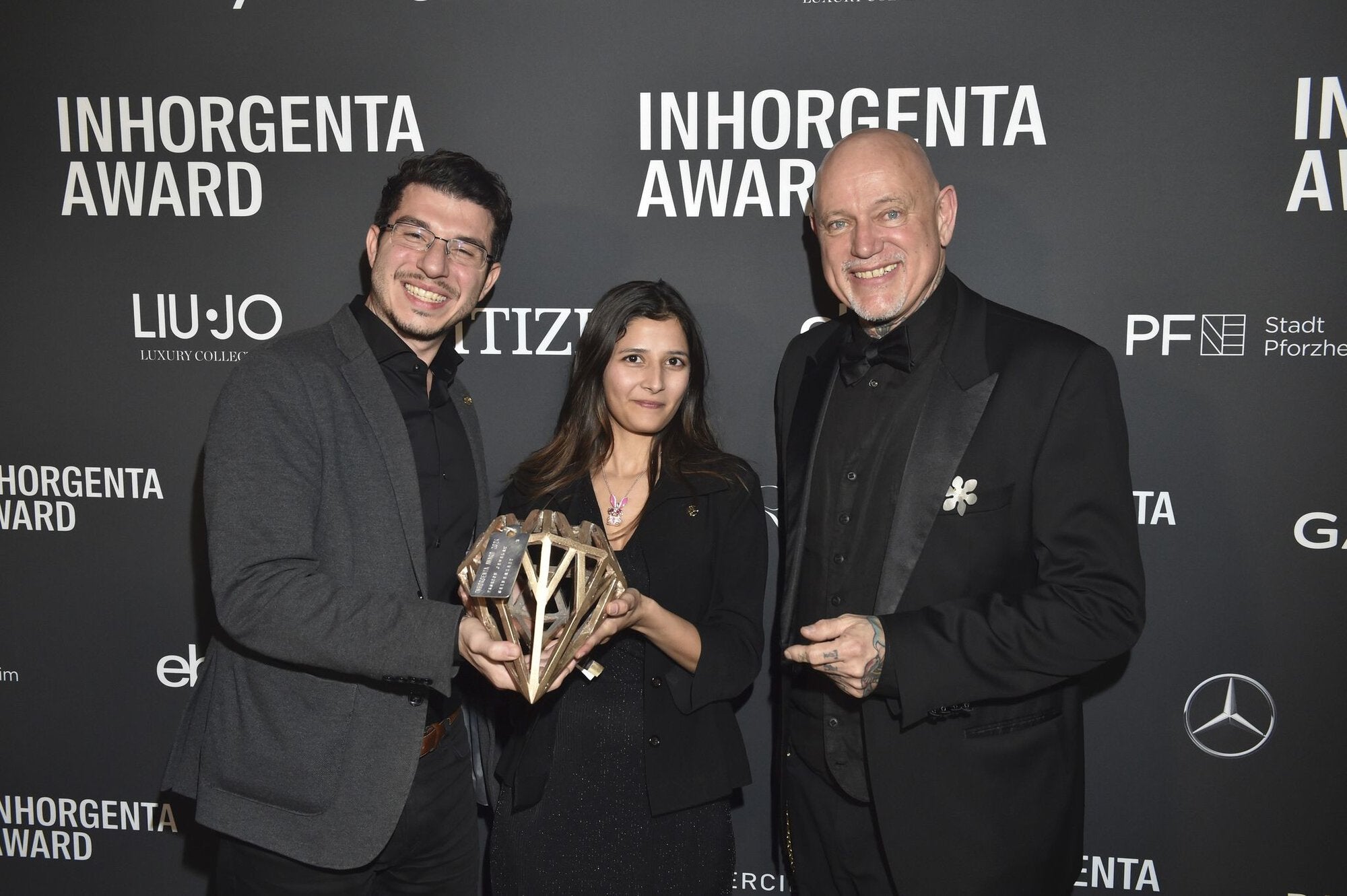 Seinerzeit team holding and posing with the award after winning the Inhorgenta Fashion Jewelry of the Year 2024 award, for Ms. Roxy Rabbit pendant with movable sunglasses