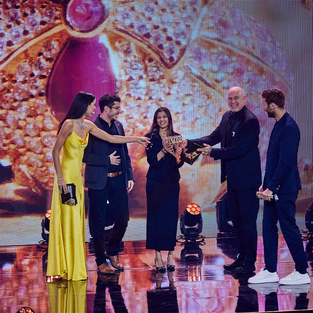Seinerzeit team recieving the award on stage for Inhorgenta Fashion Jewelry of the Year 2024 award, for Ms. Roxy Rabbit Pendant, with movable sunglasses holding trophies amid confetti.