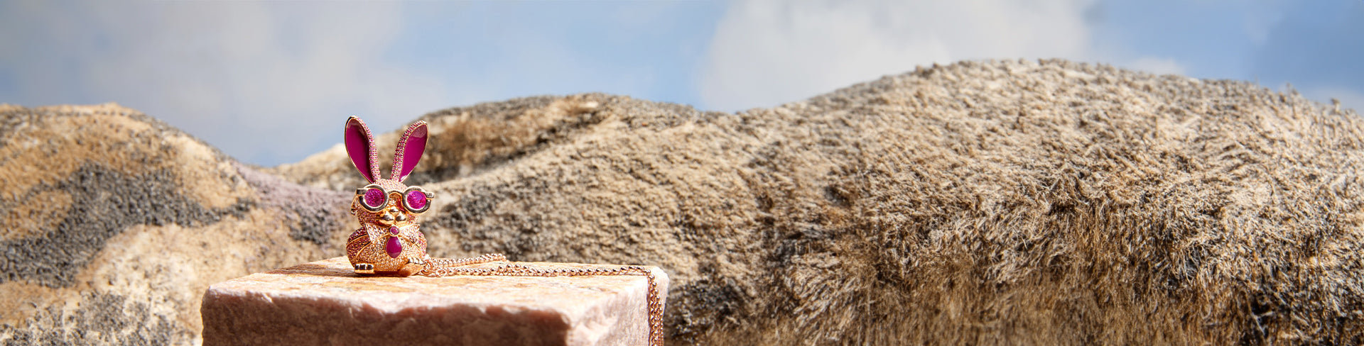 Ms. Roxy Rabbit with sunglasses pendant by Seinerzeit, winner of the Inhorgenta Fashion Jewelry of the Year 2024, displayed on stone with a desert backdrop.