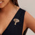 Close-up of a woman wearing the Raja Elephant design, a detailed gold and silver elephant head that functions as both a pendant and a brooch, styled on a black V-neck dress.