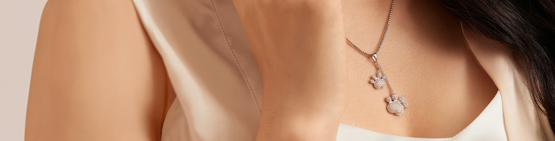 Close-up of Seinerzeit Haustiere collection paw pendant in silver with sparkling stones, worn on a delicate chain