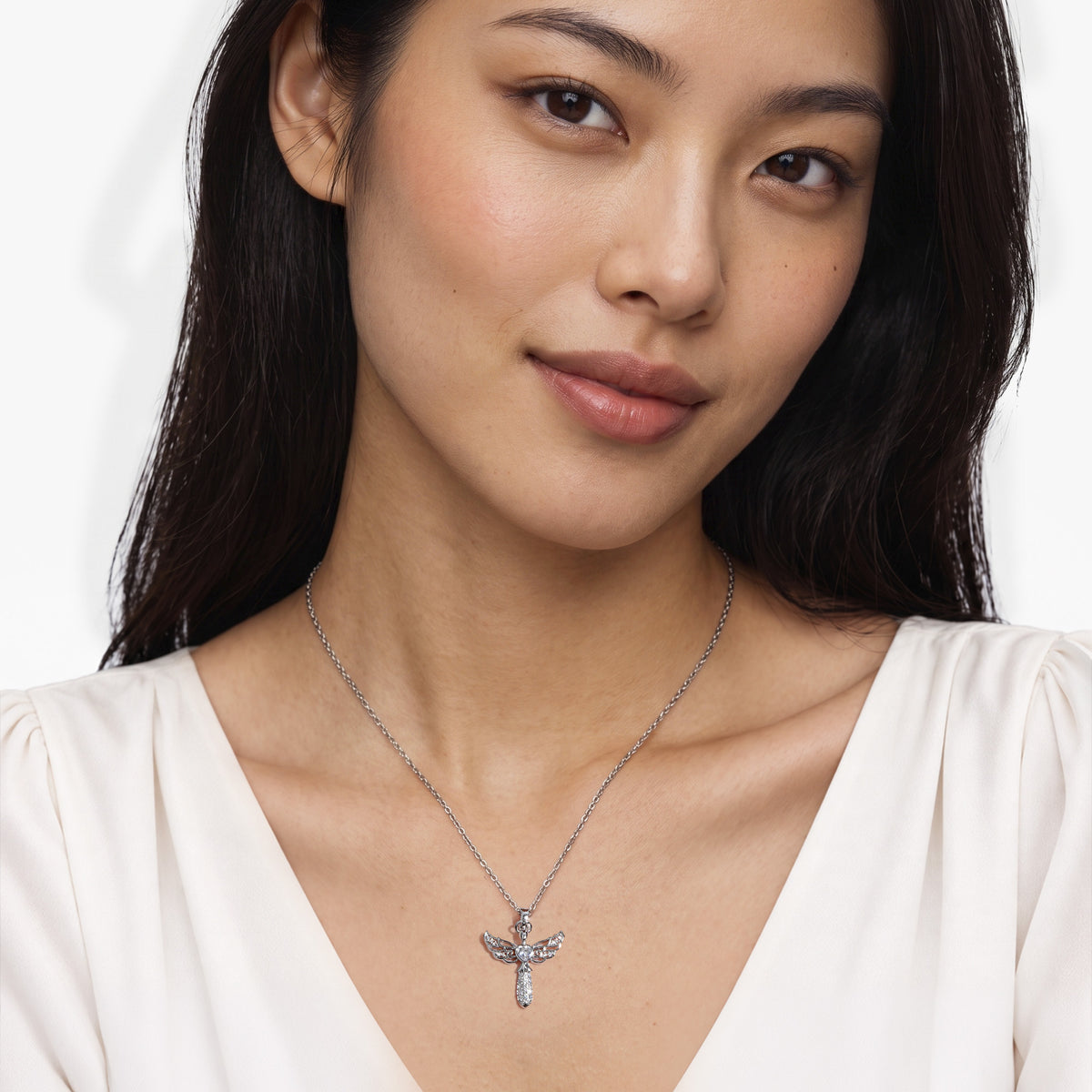 Weibliches Modell trägt den filigranen Mira Engel-Anhänger von SEINERZEIT aus 925 Sterling Silber mit weißem Herz-Zirkonia 