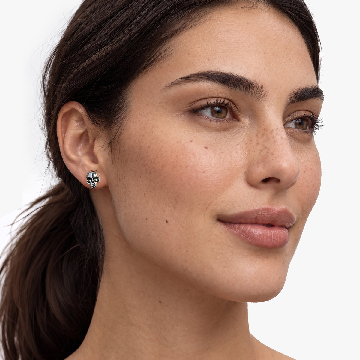 Weibliches Modell trägt die Nero Totenkopf-Ohrstecker von SEINERZEIT aus 925 Sterling Silber mit weißen Zirkonia