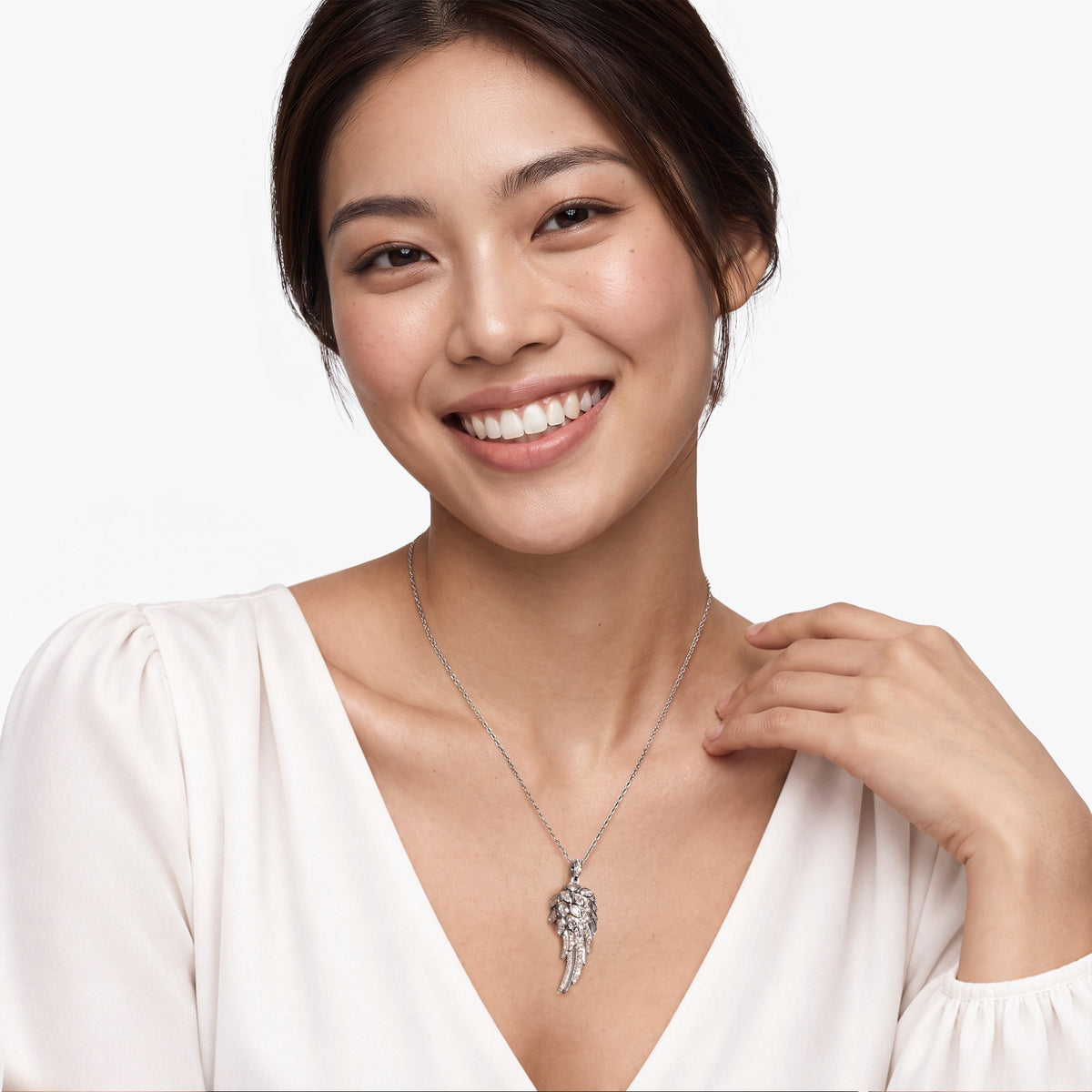 Weibliches Modell trägt den Seraph Engelsflügel-Anhänger von SEINERZEIT aus rhodiniertem 925 Sterling Silber mit weißen Zirkonia 