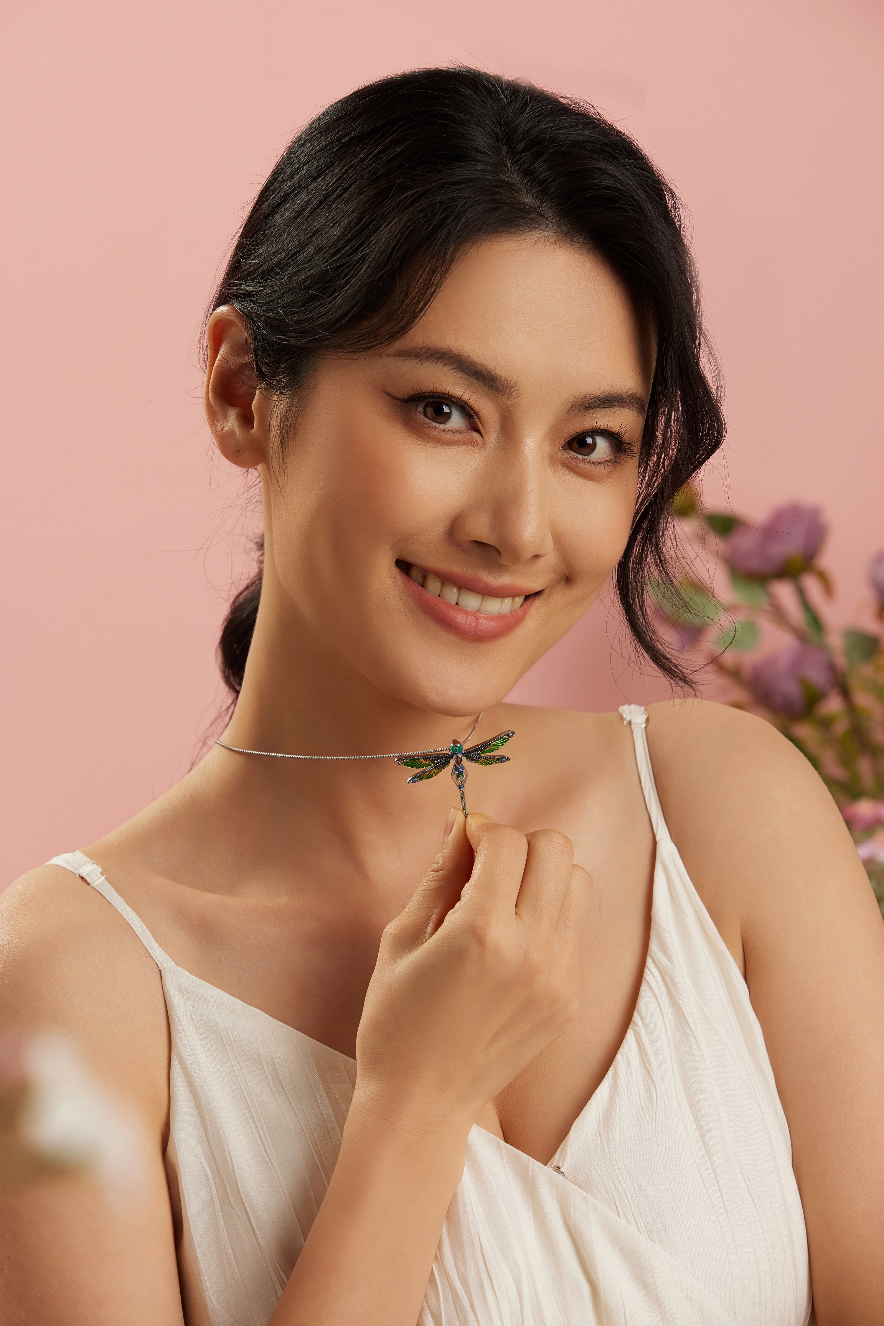 Smiling woman wearing the Ella dragonfly pendant in sterling silver with green and blue cubic zirconia, from Seinerzeit Flora & Fauna Waldleben collection
