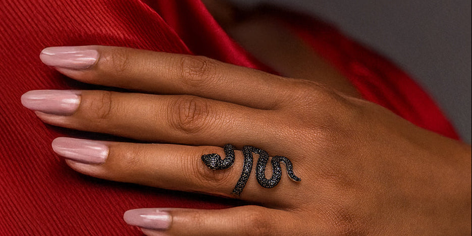 Frau trägt Mambo Schlangenring aus 925 Sterling Silber mit schwarzen Zirkonia am Finger – markanter Ring im geschwungenen Schlangendesign, Symbol für Transformation, Stärke und Verführung, eleganter Statement Schmuck der SEINERZEIT Noctis Kollektion